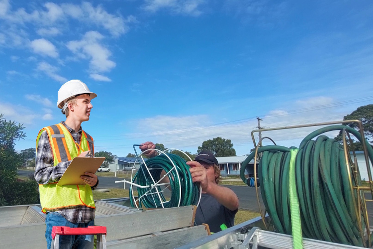 
Post-rinsing, wollongong gutter cleaner prepares his hose equipment for transport.